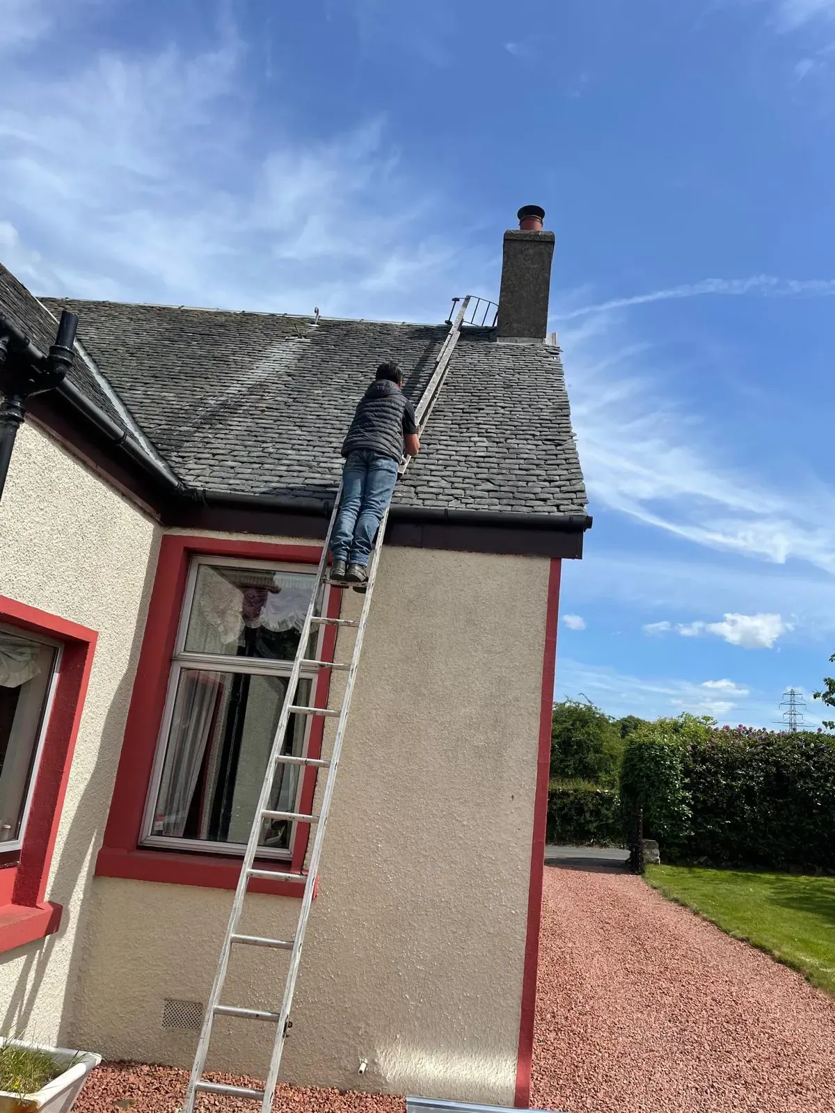 AGM roofer carrying out a ladder inspection on a traditional cottage near Falkirk